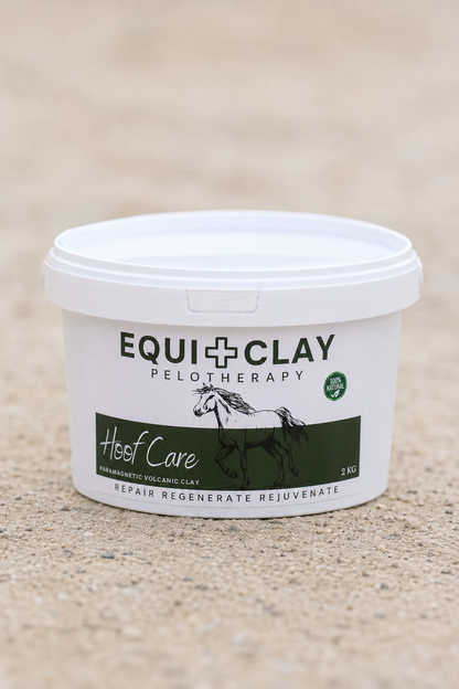 A white plastic tub of EquiClay Pelotherapy Hoof Care Natural volcanic clay, displayed on a sandy beige ground.